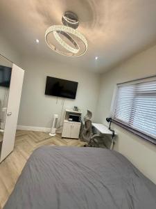 ein Schlafzimmer mit einem Bett und einem Flachbildfernseher in der Unterkunft Luxurious Bedroom and Living room in a House in Romford + 10 Fotos