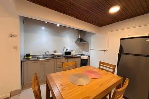 a kitchen with a wooden table and a refrigerator at CosmoSur - Centro El Bolson in El Bolsón