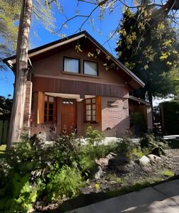 ein Haus mit einem Baum davor in der Unterkunft CosmoSur - El Bolson Centro in El Bolsón