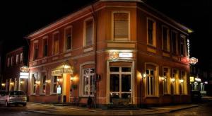 a building on the corner of a street at night at Hotel Bentheimer Eck in Bad Bentheim