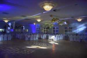 a ballroom with white tables and chairs and purple lighting at Hotel Sarai Wrocław in Wrocław