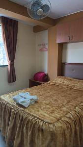 a hotel room with a bed with two towels on it at Hostal Winya in Lima