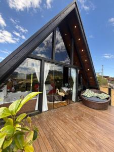 a house with large glass windows on a deck at Chalé Recanto da Coruja in Barracão