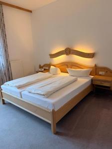 a bedroom with a large bed with a wooden headboard at Hotel Gruberhof Innsbruck Igls B&B in Innsbruck