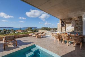 a patio with a table and chairs and a pool at Villa VIEW - GH6 in Gialova