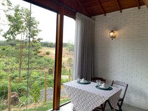 a table and chairs in a room with a large window at Chalé Colibri Verde in Santa Teresa