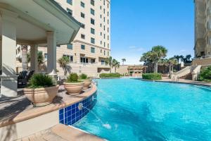 una piscina con piante in vaso accanto a un edificio di Indigo East Unit 1703E a Perdido Key