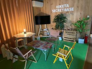 Zimmer mit Stühlen, einem Tisch und einem TV in der Unterkunft Guesthouse HIKETA Secret Base - Vacation STAY 92223v in Higashikagawa