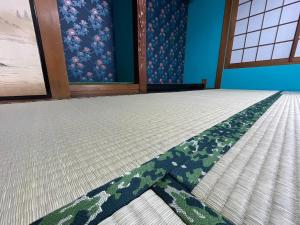 Zimmer mit einem Bett mit gemustertem Teppich in der Unterkunft Guesthouse HIKETA Secret Base - Vacation STAY 92223v in Higashikagawa