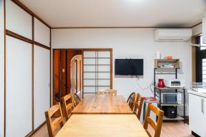 ein Esszimmer mit einem Holztisch und Stühlen in der Unterkunft Guesthouse HIKETA Secret Base - Vacation STAY 92223v in Higashikagawa