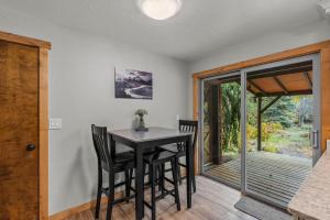 ein Esszimmer mit einem Tisch und Stühlen sowie einer Glasschiebetür in der Unterkunft Diamond in Deschutes River Woods