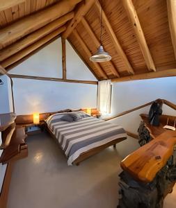 ein Schlafzimmer mit einem Bett und einer Holzdecke in der Unterkunft Los Retoños in El Bolsón
