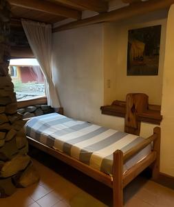 ein Schlafzimmer mit einem Bett in einem Zimmer mit einem Fenster in der Unterkunft Los Retoños in El Bolsón