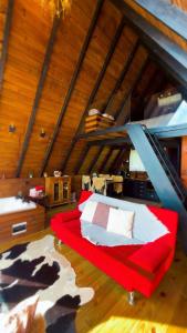 a bedroom with a red bed in a attic at Chalé Recanto da Coruja in Alfredo Wagner