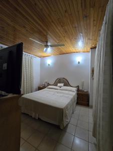 a bedroom with a large bed with a wooden ceiling at Esquina Mburucuya in Asunción +21 photos