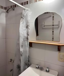 ein Badezimmer mit Waschbecken und Spiegel in der Unterkunft La Perla in El Bolsón