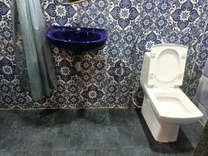 a bathroom with a toilet and a blue sink at Carolina Deluxe GuestHouse Wi-Fi in Colva