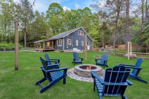 Un grupo de sillas alrededor de una fogata en un patio. en Hare & Hollow with Hot Tub & Fenced Yard, en Long Eddy