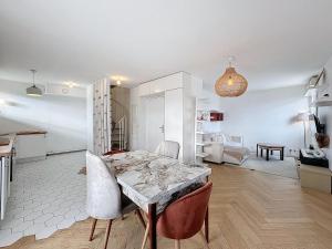 Apt 6p-Standing RER Paris 15 min في جوافيل: مطبخ وغرفة معيشة مع طاولة وكراسي