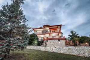 帕拉塔蒙Villa Nestor的山丘上的房子,前面有一棵树