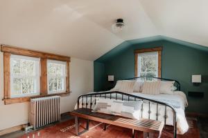 1930's Vintage Cabin Hot Tub Kohler Cabin في Jeffersonville: غرفة نوم بسرير ومقعد ونوافذ