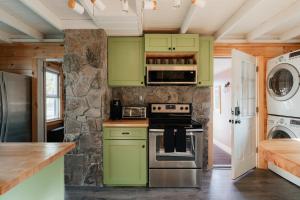 1930's Vintage Cabin Hot Tub Kohler Cabin في Jeffersonville: مطبخ مع دواليب خضراء وموقد