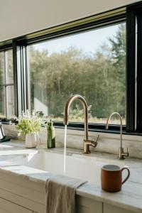 eine Küchenspüle mit zwei Armaturen und einem Fenster in der Unterkunft Onyx Ridge Breathtaking Views 14 Acres in Jeffersonville + 39 Fotos