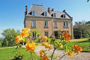 an old house with orange flowers in front of it at Domaine de Gaudon in Ceilloux