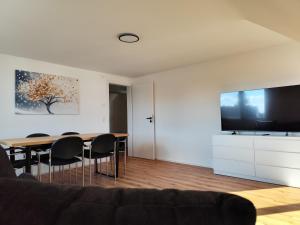 a living room with a table and a flat screen tv at FeWo Relaxfit in Bad Buchau