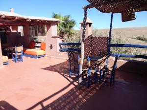 a patio with two chairs and an umbrella at dar boumida in Lalla Takerkoust