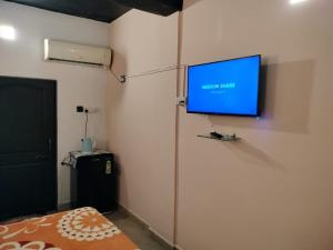 a room with a flat screen tv on the wall at Carolina Deluxe GuestHouse Wi-Fi in Colva +17 photos