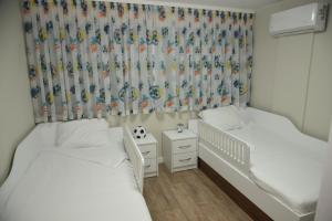 ein Schlafzimmer mit 2 Betten und einem Kinderbett in der Unterkunft C&A Apartment in Goze Deltschew