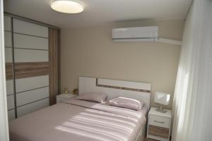 ein weißes Schlafzimmer mit einem Bett mit zwei Kissen in der Unterkunft C&A Apartment in Goze Deltschew