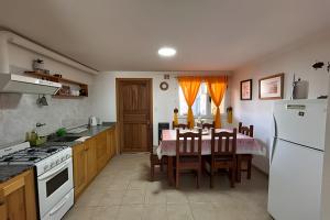 a kitchen with a table and a white refrigerator at Copos de Nieve in El Bolsón
