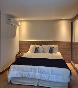 ドミンゴス・マルチンスにあるApart Vista Azul - Conforto com a vista para a mata de pinheirosの部屋の中に大きなベッドがある寝室