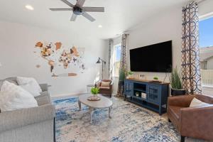 un salon avec un canapé et une télévision dans l'établissement Western Explorer Two Homes Sleeps 20, à Caldwell