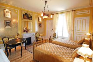 a bedroom with a bed and a table and a window at Domaine de Gaudon in Ceilloux