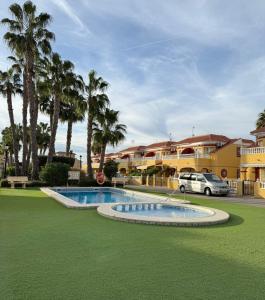 a resort with a swimming pool and palm trees at La Macarena Torrevieja in Torrevieja