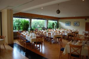 un comedor con mesas y sillas blancas en Hotel Hubertushof, en Lingen
