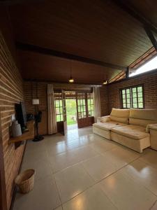 ein großes Wohnzimmer mit einem Sofa und einem TV in der Unterkunft Cactus Chalés & Cabanas em lumiar in Lumiar