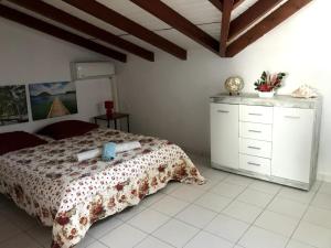 ein Schlafzimmer mit einem Bett und einer Kommode in der Unterkunft Ambre des iles in Sainte-Anne