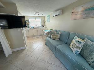 ein Wohnzimmer mit einer blauen Couch und einer Küche in der Unterkunft Cozy Beach Rental 1B/1B in St Pete Beach