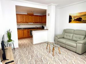 a living room with a couch and a kitchen at La Macarena Torrevieja in Torrevieja