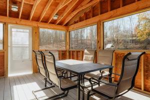 ein Esszimmer mit einem Tisch und Stühlen auf einer Veranda in der Unterkunft Swan Pond Cabin Hot Tub & Firepit Retreat in Swan Lake