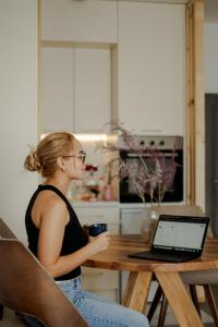 a woman sitting at a table with a laptop computer at LALA & DAUGHTERS Apartment in Vrnjačka Banja +18 photos