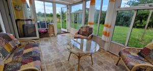 a screened in porch with a glass table and chairs at Molsness in Knebel