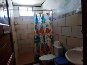 a bathroom with a shower curtain and a toilet at Lodge Mar y Sol in Sámara +114 photos