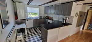 a kitchen with gray cabinets and a black counter top at Molsness in Knebel