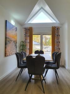 a dining room with a table and chairs and a large window at Zimmer-Vermietung an der Ostsee, neben der Median-Klinik in Wismar