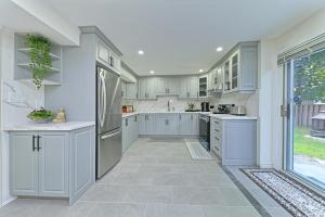 Una cocina con gabinetes blancos y un refrigerador. en SPACIOUS FULLY PRIVATE 2BR UNIT ON GROUND LEVEl, en Burlington 14 fotos más